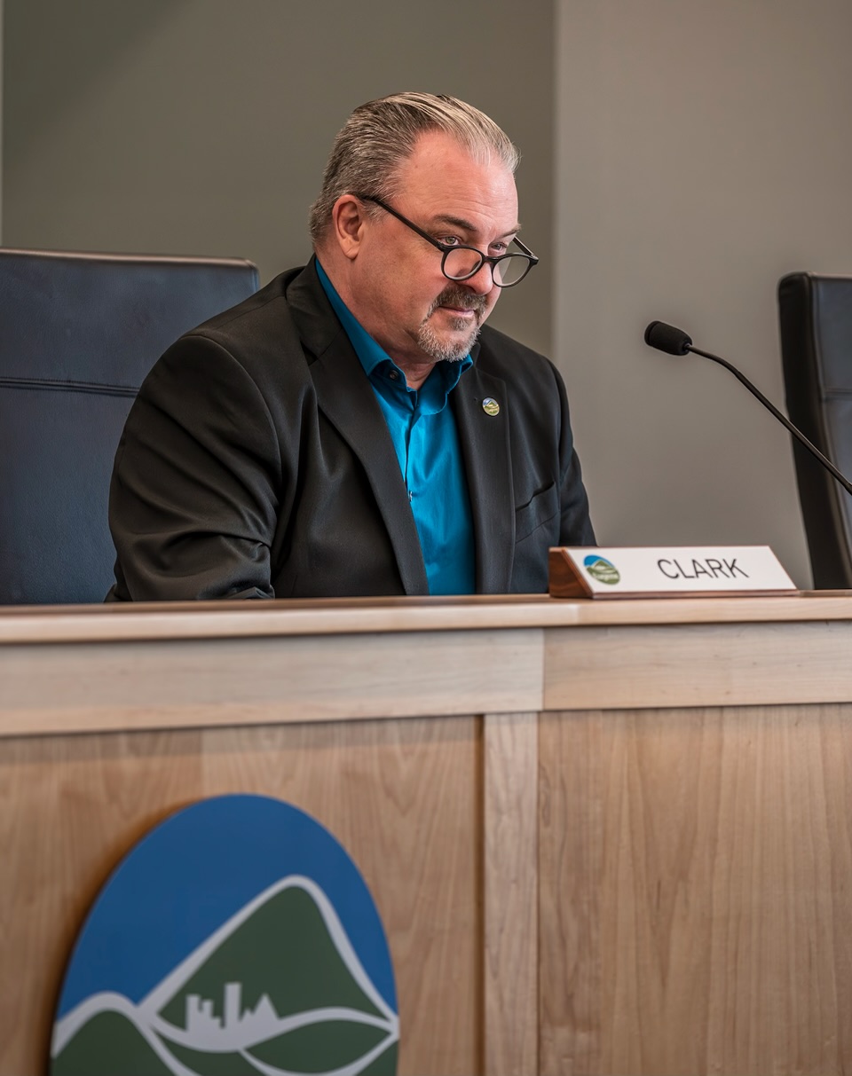 Mike Clark reviewing materials at the Eugene City Council dais